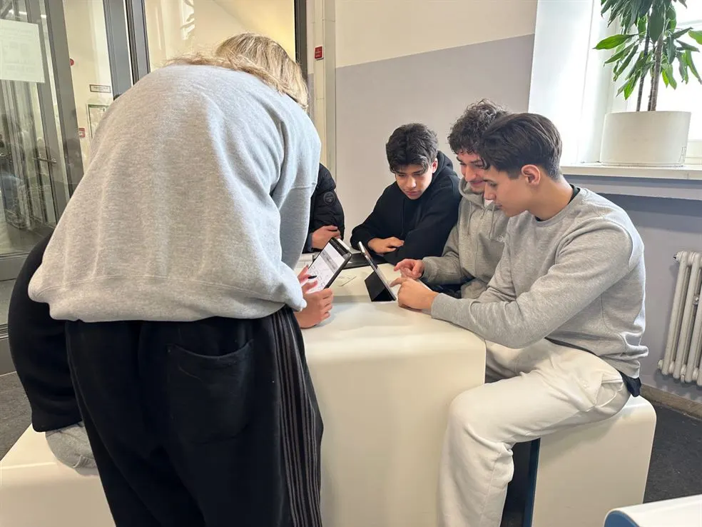 Vier Schülerinnen und Schüler arbeiten gemeinsam an einem Tablet