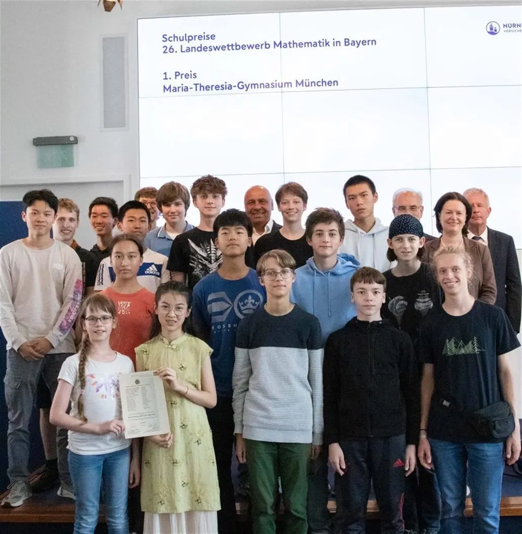 Die Preisträgerinnen und Preisträger des MTG bei der Verleihung des Schulpreises, im Hintergrund die Leinwand mit der Auszeichnung