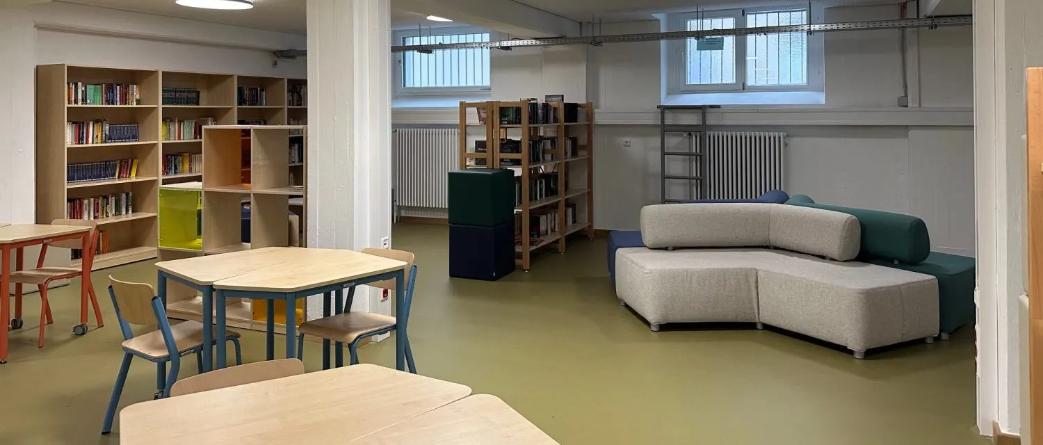 Die neue Schulbibliothek mit Regalen, Arbeitstischen und einer Sitzlandschaft