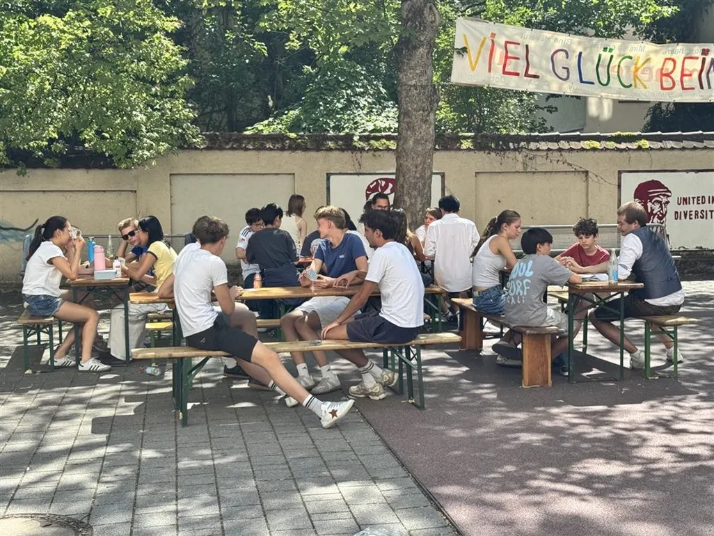 Schülerinnen und Schüler beim Schafkopfturnier an Bierbänken im Pausenhof