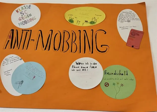 Orangefarbenes Plakat „Anti-Mobbing“ einer fünften Klasse