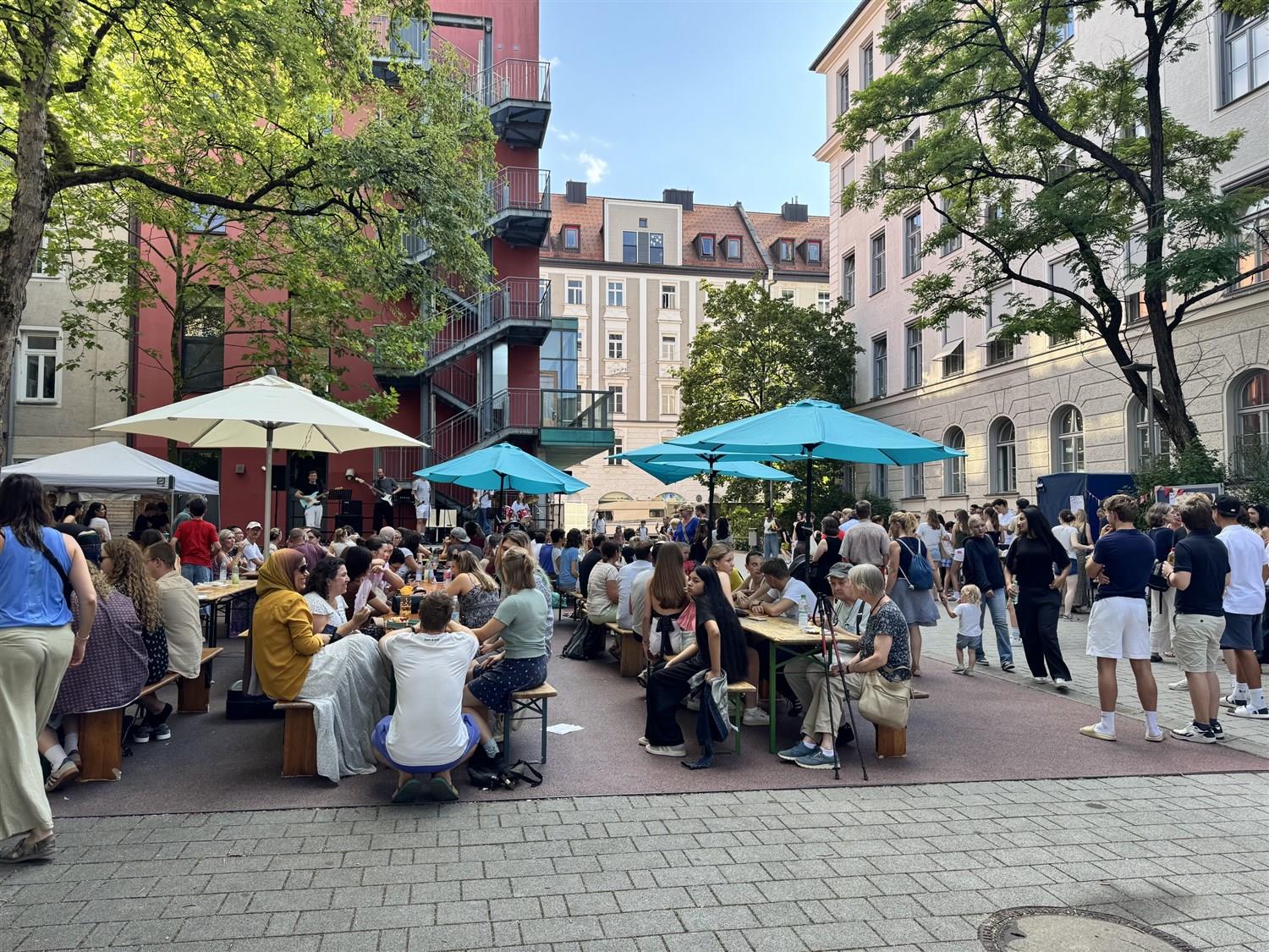Sommerfest im Pausenhof: Biertische, Sonnenschirme und eine Band, dicht besetzt von Gästen aller Generationen