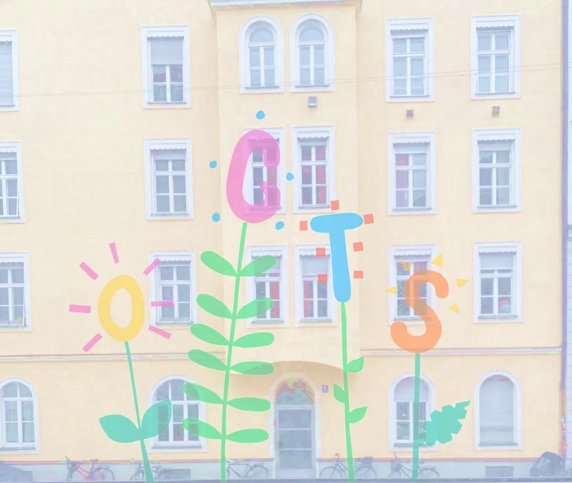 Buntes Fensterbild mit dem Schriftzug OGTS aus Blumen